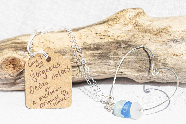 Sterling silver heart with sea glass necklace. Hand crafted. Backdrop of rustic driftwood.